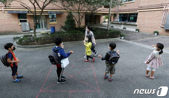 지난달 21일 경기 군포시 소재 한 초등학교에서 유치원생들이 등원하며 서로 인사를 나누고 있다./뉴스1 © News1
