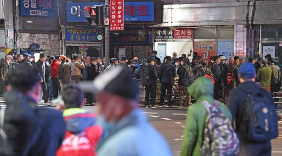 17일 서울 남구로역 인근 인력시장에서 일용직 근로자들이 일감을 구하기 위해 밀집해 모여 있다.