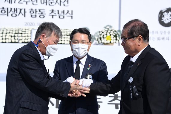 19일 여수시 중앙동 이순신광장 일대에서 열린 제72주년 여순사건 합동 추념식에서 윤정근 여순사건 유족회장과 순직 경찰 유족대표가 화해와 상생의 악수를 하고 있다.사진=여수시 제공