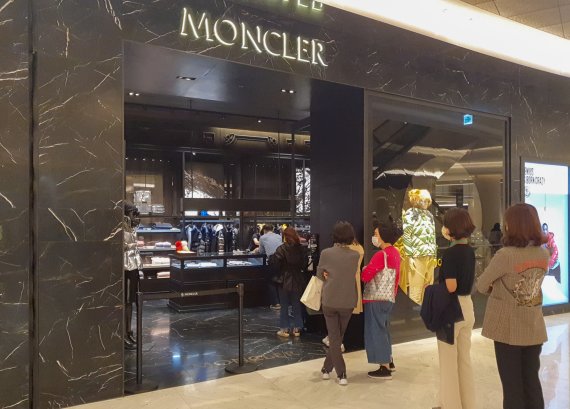롯데백화점 잠실점 에비뉴엘 몽클레르 매장 앞에서 고객들이 패딩을 사기 위해 기다리고 있다.
