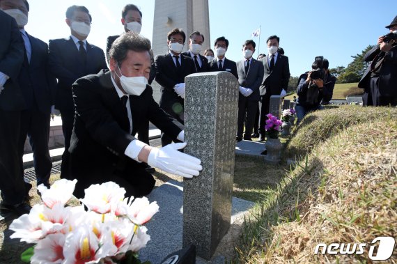 이낙연 더불어민주당 대표가 24일 국립5·18민주묘지에서 참배를 마친 뒤 무릎 꿇고 윤상원 열사 묘비를 바라보고 있다. 사진=뉴스1