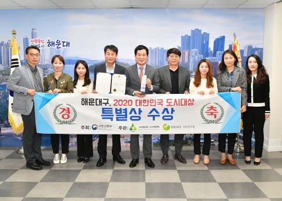 26일 부산 해운대구 홍순헌 구청장(가운데)이 '2020 대한민국 도시대상' 특별상 수상을 기념하는 현수막을 들고 있다. 해운대구청 제공