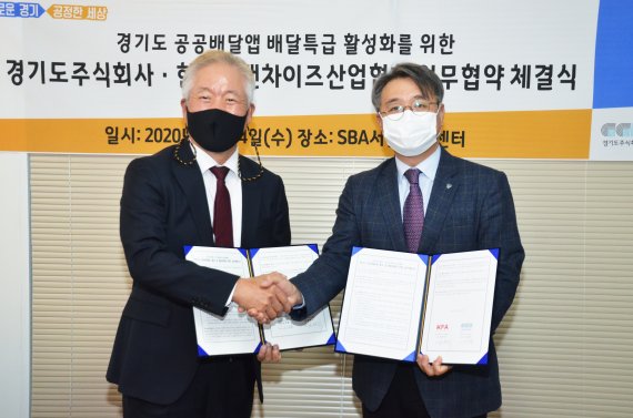 정현식 한국프랜차이즈산업협회장(왼쪽)과 이석훈 경기도주식회사 대표가 협약서 서명 후 기념 촬영을 하고 있다.
