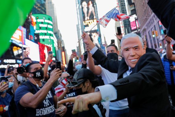 미국 뉴욕 타임스퀘어에서 7일(현지시간) 마스크를 쓴 민주당 지지자들이 조 바이든 대선 당선을 축하하고 있다.로이터뉴스1