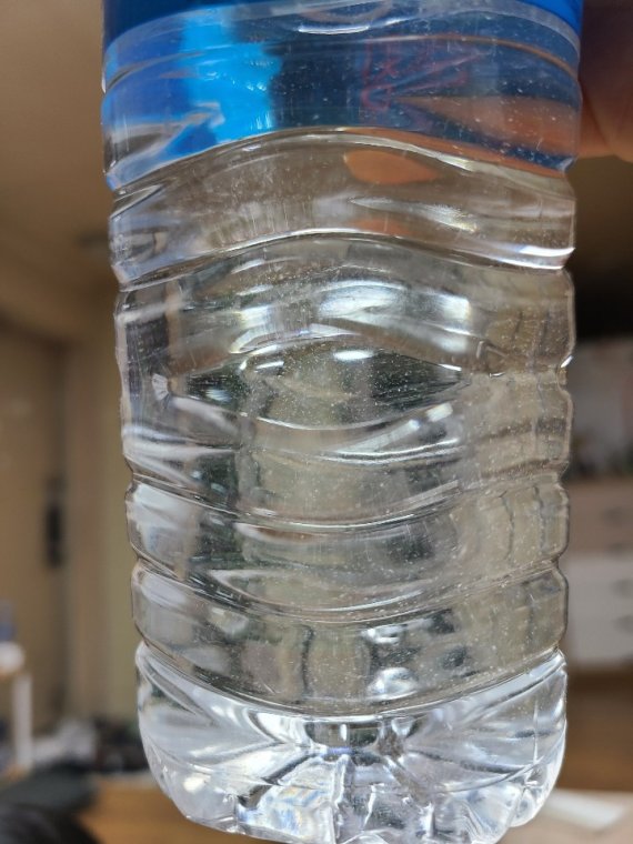 생수를 자세히 보면 이물질이 보인다. 이 생수는 유통기한도 지났다. 사진캡처