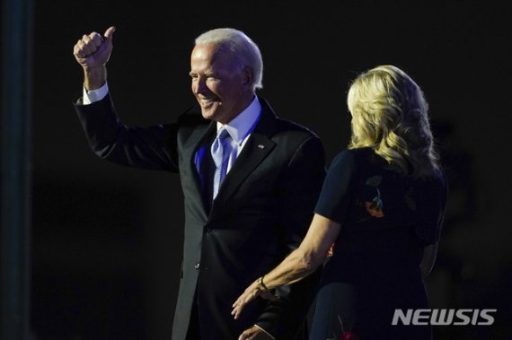 조 바이든 대통령 당선인이 7일(현지시간) 미 델라웨어주 윌밍턴에서 대국민 연설을 마치고 부인 질 바이든과 함께 손을 들고 있다. /뉴시스