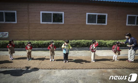 코로나19 부문 최우수상 수상작인 '낯선 거리두기'(이기범作). 유치원에 등원한 아이들이 거리두기를 지키며 발열체크와 손소독을 하고 있는 모습을 담았다.© 뉴스1
