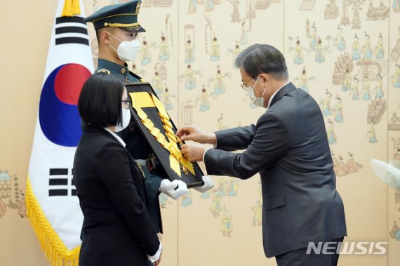 [서울=뉴시스]박영태 기자 = 문재인 대통령이 12일 청와대 본관에서 열린 전태일 열사 훈장 추서식에 참석해 전태일 열사의 둘째동생 전순옥 씨 옆의 의장병이 들고 있는 추서판에 부장을 걸어주고 있다. 2020.11.12. since1999@newsis.com /사진=뉴시스