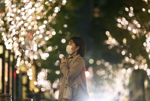 한 젊은 여성이 크리스마스 트리가 장식된 도쿄의 한 거리를 거닐고 있다. AP뉴시스