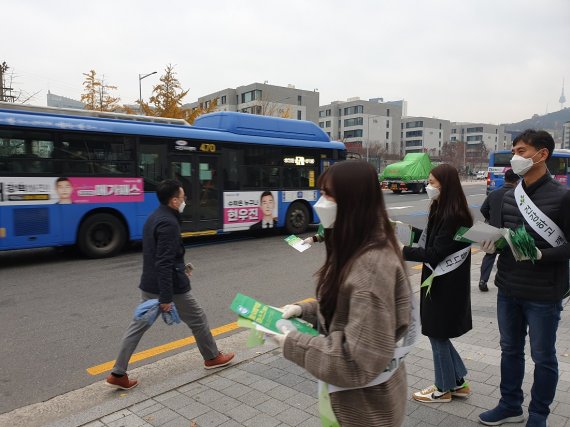 깨끗한나라 임직원들이 13일 서울 한남대로에 위치한 본사 인근 버스 환승역에서 마스크를 무료로 나눠주고 있다. 깨끗한나라 제공