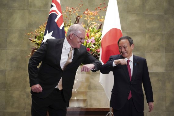 지난 17일 스콧 모리슨 호주 총리와 스가 요시히데 일본 총리가 도쿄 총리 관저에서 공식 환영행사 시작에 앞서 팔꿈치 인사를 나누고 있다. AP뉴시스
