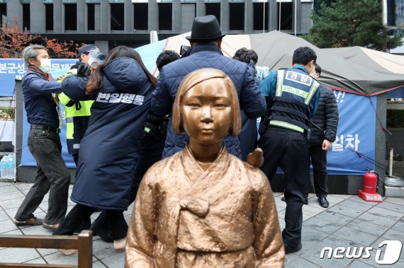 18일 오후 서울 종로구 옛 일본대사관 앞에서 일본군 위안부 문제해결을 위한 제1466차 수요시위를 앞두고 반일행동 회원이 보수단체와 실랑이 과정에서 경찰에 연행되고 있다. /사진=뉴스1