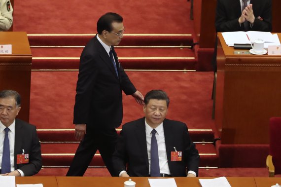 중국 권력 서열 1, 2위인 시진핑 국가주석(오른쪽)과 리커창 총리가 19일 국내외 발언 수위를 높였다. 지난 5월 중국 베이징 인민대회당에서 열린 전국인민대표대회에서 리 총리가 시 주석의 뒤를 지나가고 있다. 뉴시스