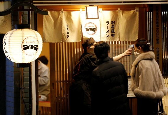 27일 도쿄의 한 식당에서 점포 입장 전 이용객의 체온을 확인하고 있다. 로이터 뉴스1