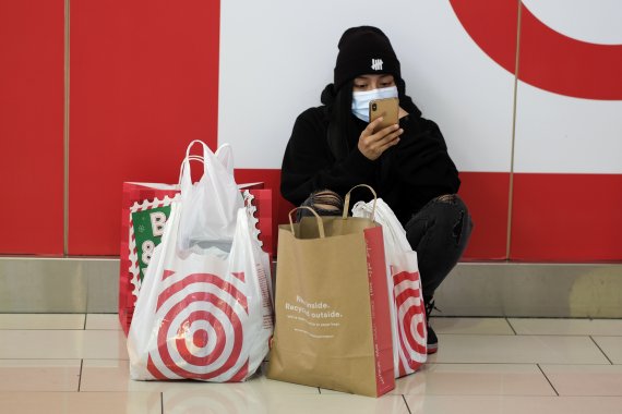27일(현지시간) 블랙프라이데이 쇼핑축제에 참가한 한 쇼핑객이 미국 캘리포니아 소재 한 매장 앞에서 쇼핑물품을 앞에두고 앉아 있다. AP뉴시스