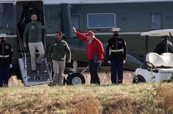 도널드 트럼프(붉은색 점퍼) 미국 대통령이 28일(현지시간) 버지니아주 스털링에 있는 자신 소유의 '트럼프 내셔널 골프 클럽'에 도착해 헬기에서 내리고 있다. 사진=로이터뉴스1
