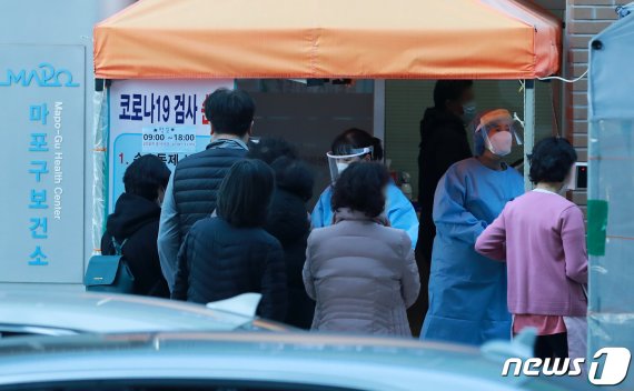 30일 오후 서울 마포구청에 마련된 신종 코로나바이러스 감염증(코로나19) 선별진료소에서 의료진이 검사를 받기 위해 방문한 시민을 안내하고 있다. 2020.11.30/뉴스1 © News1 구윤성 기자