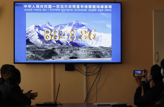 네팔 정부 관리들이 8일 수도 카트만두에서 중국과 공동으로 진행된 에베레스트산 높이 발표 중계 방송을 지켜보고 있다. 양국은 에베레스트산의 높이가 종전의 수치에 비해 높아진 8848.86m에 합의했다고 발표했다.AP뉴시스