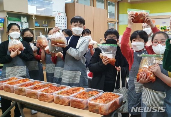 [안동=뉴시스] 김진호 기자 = 안동 송현초등학교 학생들이 지역의 홀로 어른신들께 전달할 김장을 담그고 있다. (사진=송현초등학교 제공) 2020.12.09 photo@newsis.com