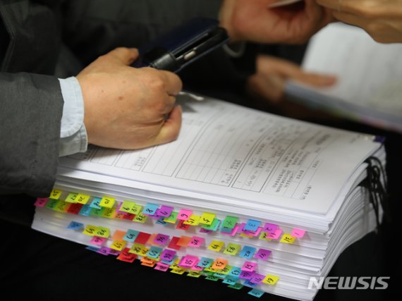[서울=뉴시스] 박주성 기자 = 10일 오전 서울 중구 진실·화해를위한과거사정리위원회 민원실에서 진실규명 신청을 하기 위해 찾아온 한 시민이 빼곡히 정리한 자료를 들고 있다. (공동취재사진). 2020.12.10. photo@newsis.com