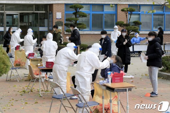 10일 오후 광주 광산구 한 고등학교에서 학생들이 신종 코로나바이러스 감염증(코로나19) 진단 검사를 받고 있다. 광주시에 따르면 전날 해당 학교 교사 1명이 확진 판정을 받아 방역당국이 임시 선별진료소를 설치, 재학생과 교직원 등 400여명에 대한 검체 채취를 진행 중이다. 2020.12.10/뉴스1 © News1 정다움 기자
