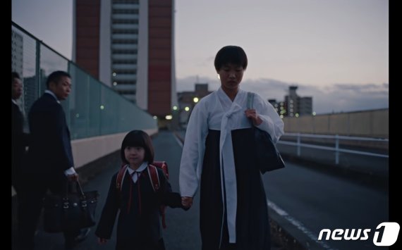 지난달 27일 나이키 재팬(NIKE JAPAN)이 공개한 온라인 동영상 광고 속 한 장면. 검정 치마저고리를 입고 가는 재일 조선인 여학생에게 따가운 시선이 쏟아진다. ('나이키 재팬' 유튜브 갈무리)© 뉴스1