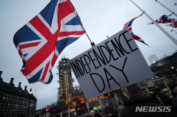 [런던=AP/뉴시스] 31일(현지시간) 영국 런던 국회의사당 주변에서 브렉시트 찬성 시위대가 '독립기념일'이라고 적힌 푯말을 들고 있다. 영국은 이날 유럽연합(EU)을 공식 탈퇴한다. 2020.02.01
