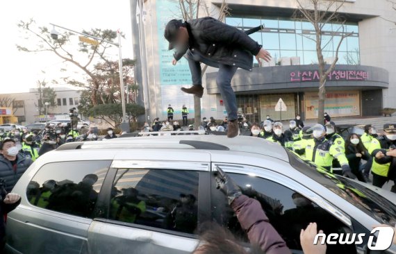 지난 12일 오전 안산시내에서 한 유튜버가 거주지로 향하는 조두순이 탑승한 차량을 공격하고 있다. 2020.12.12/뉴스1 © News1 조태형 기자