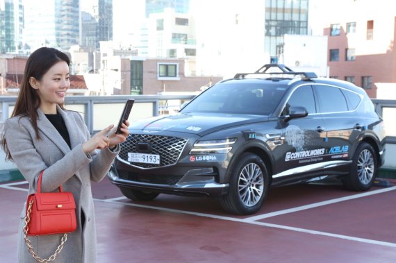 LG유플러스 모델이 서울시 상암 5G 자율주행 시범지구의 한 주차장에서 모바일 앱을 통해 5G 자율주행차 A1의 주차를 완료시키고 있다. LG유플러스 제공