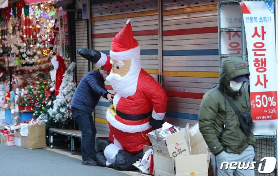 크리스마스를 닷새 앞둔 20일 서울 동대문구 창신동 문구거리에서 한 자영업자가 쓰러지는 산타 인형을 일으켜 세우고 있다. 2020.12.20 /사진=뉴스1