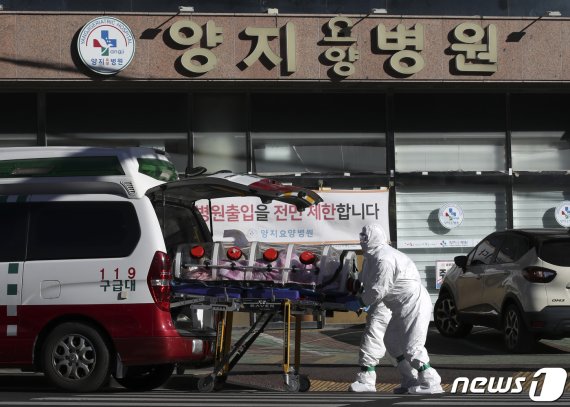 17일 오후 신종 코로나바이러스 감염증(코로나19) 집단 감염이 발생한 울산 남구 양지요양병원 앞에서 소방대원들이 확진자를 이송하기 위해 구급차로 옮기고 있다. /뉴스1 © News1 윤일지 기자 /사진=뉴스1