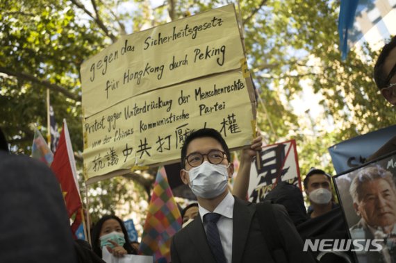 [베를린=AP/뉴시스]2020년 9월1일 홍콩 활동가 네이선 로((羅冠聰, 가운데)가 독일 베를린에서 왕이(王毅) 중국 외교부장의 방문 중 시위에 참가하고 있다. 2020.10.21