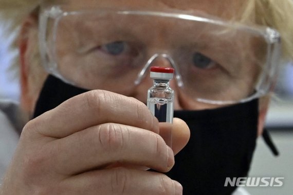 보리스 존슨 영국 총리가 지난 11월 웨일스주 레스섬에 있는 워크하르트 제약 제조 시설에서 'AZD1222'로 알려진 다국적 제약사 아스트라제네카의 코로나19 백신을 들고 있다. 사진=뉴시스