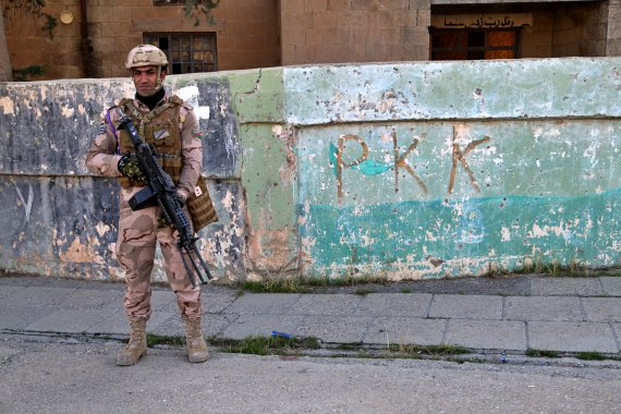 지난해 12월 4일 이라크 신자르 지역에서 이라크 군인이 '쿠르드노동자당(PKK)'과 관련된 낙서 옆에 서 있다.AP뉴시스