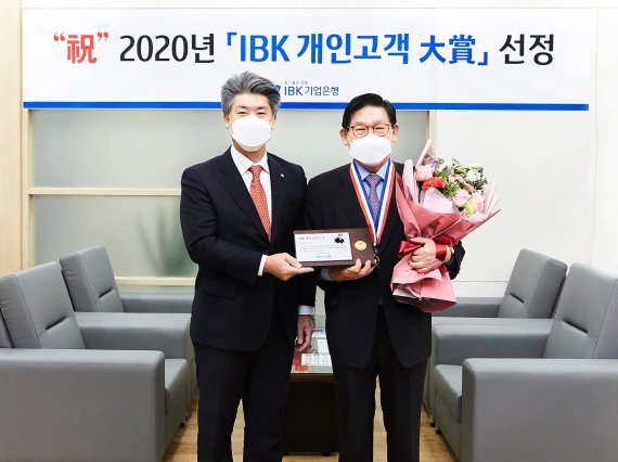 지난 30일 기업은행 강남지역본부 회의실에서 윤종원 IBK기업은행장(왼쪽)과 이홍근 고객이 감사패를 들고 기념촬영을 하고있다. 사진=기업은행