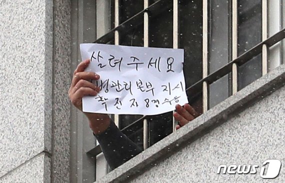 대규모 집단감염이 발생한 서울 동부구치소에 수용된 재소자가 지난 29일 자필로 '살려주세요'라고 쓴 문구를 내보이고 있다. © News1 이성철 기자