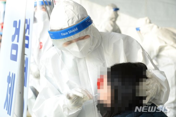 [울산=뉴시스] 배병수 기자 = 신종 코로나바이러스 감염증(코로나19)이 전국적으로 확산하고 있는 가운데 23일 오전 울산 울주군 범서생활체육공원에 마련된 선별진료소에서 의료진이 검체 채취를 하고 있다. 2020.12.23. bbs@newsis.com.