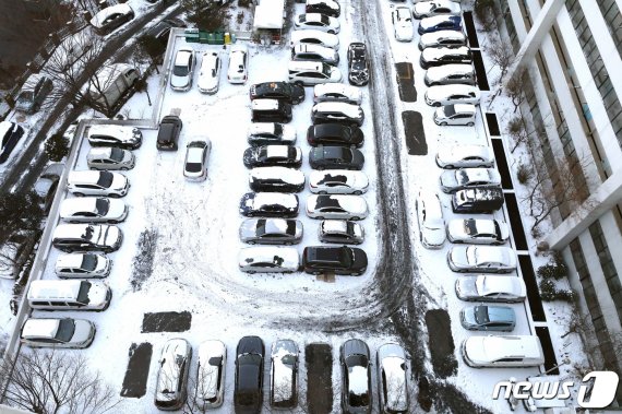 지난 7일 오전 서울 시내의 한 아파트 주차장에 밤새 쌓인 눈으로 인해 차량을 두고 출근한 시민들의 차가 주차돼 있다. 뉴스1