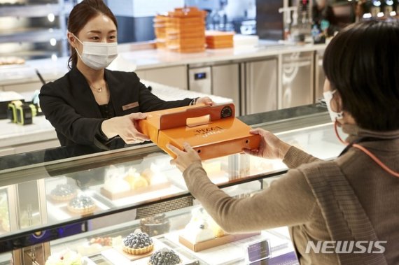 [서울=뉴시스]워커힐 '르 파사쥬'의 '오픈키친'에서 피자를 테이크 아웃하는 여성 고객