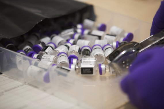 지난해 12월8일(현지시간) 영국 브리스톨 사우스메드 병원 직원이 화이자-바이오엔테크의 코로나19 백신을 정리하고 있다.AP뉴시스