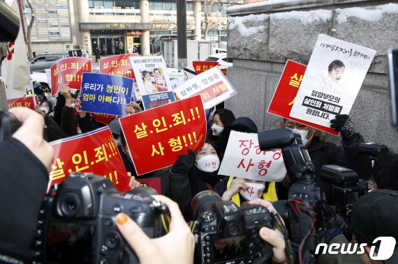 정인양을 입양한 후 수개월간 학대해 사망에 이르게 한 혐의를 받는 양부모에 대한 첫 재판이 열리는13일 오전 서울 양천구 서울남부지방법원 앞에서 호송차량이 들어가자 대한아동학대방지협회 회원들과 시민들이 손펫말을 든 채 구호를 외치고 있다. 뉴스1