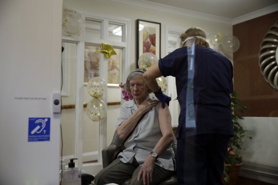 13일(현지시간) 영국 런던 남서부의 한 요양원에서 91세 거주자가 코로나19 백신을 접종받고 있다.AP뉴시스