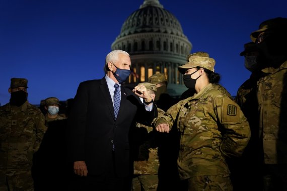 마이크 펜스가 미국 부통령 시절이던 지난해 1월 14일(현지시간) 워싱턴 의사당에서 경계근무를 서고 있는 주방위군 대원과 팔꿈치 인사를 나누고 있다. 로이터뉴스1