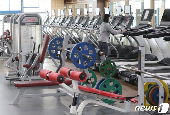 지난 17일 오후 경기 부천시 웅진플레이도시 헬스장에서 관계자가 운동기구를 소독하며 영업을 준비하고 있다./뉴스1 © News1 이성철 기자
