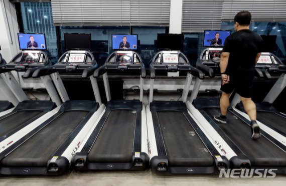 [서울=뉴시스]김병문 기자 = 헬스장 등 실내체육시설에 대한 집합금지·운영제한이 완화된 18일 오전 서울 중구 한 헬스장에서 한 회원이 문재인 대통령의 2021 신년 기자회견을 시청하고 있다. 2021.01.18. dadazon@newsis.com