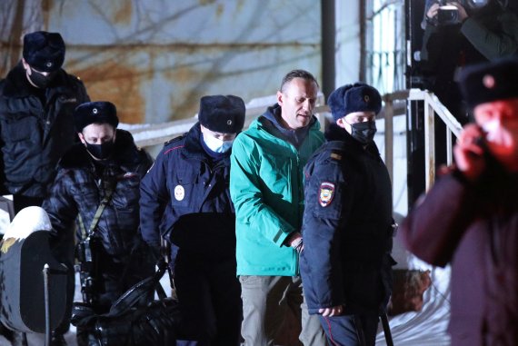 러시아 재야 지도자인 알렉세이 나발니(가운데 하늘색 점퍼)가 18일(현지시간) 모스크바 외곽 킴키에서 경찰들의 손에 이끌려 법원에 들어서고 있다. 사진=로이터뉴스1