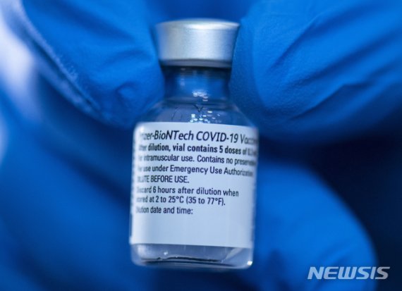 19일 독일 대도시의 백신 센터에서 의료진이 화이자-비오엔테크 코로나 19 백신 주사약병을 들고 있다. /사진=뉴시스화상