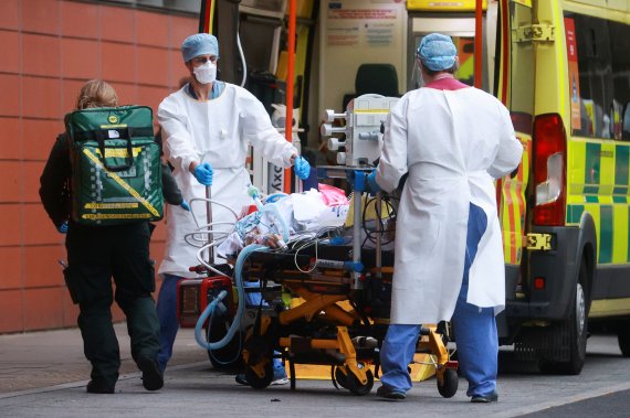 영국 보건당국 직원들이 19일(현지시간) 수도 런던의 왕립런던병원에서 코로나19 확산을 방지하기 위해 환자를 다른 장소로 이송하고 있다.로이터뉴스1