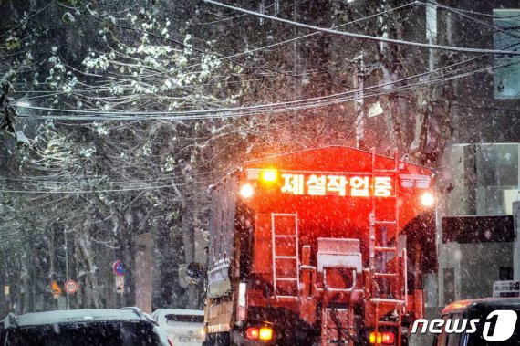 서울에 많은 눈이 내린 6일 오후 홍대입구역 인근에 눈이 쌓이자 제설차량이 염화칼슘을 뿌리고 있다. 2020.1.6/뉴스1 © News1 황덕현 기자