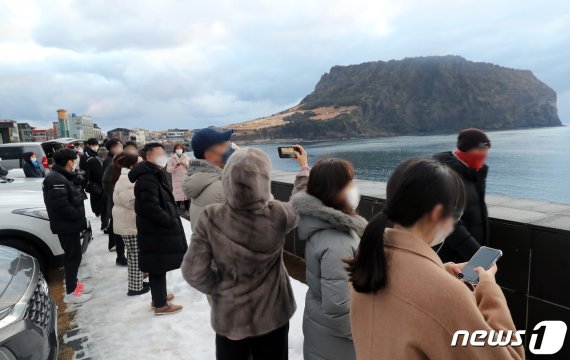 1일 오전 제주 서귀포시 성산일출봉 인근 해변에 해맞이객들이 몰려 있다. 2021.1.1/뉴스1 © News1 오현지 기자